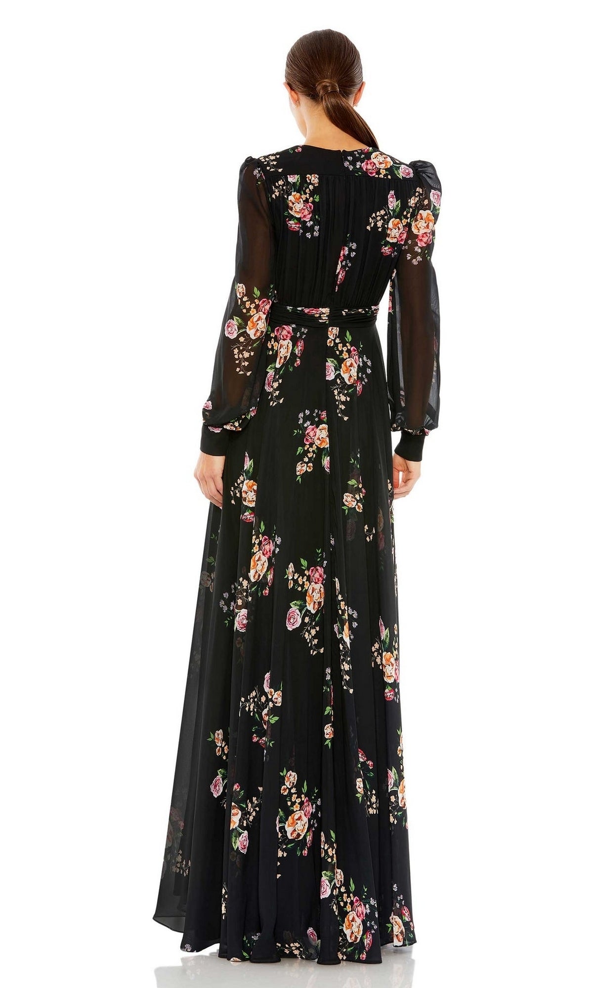 A woman stands facing away, wearing the Mac Duggal 55661—a long black print formal dress with colorful flowers and sheer long sleeves.